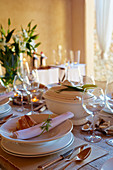Mediterran gedeckter Tisch mit weißem Geschirr und Silberbesteck