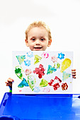 Little boy proudly presenting his potato-print picture