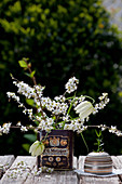Schachbrettblumen und Schlehenzweige in alter Blechdose