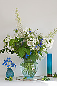 Lavish blue-and-white flower arrangement of phlox, delphiniums and raspberry stems