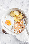 Simple buddha bowl - Fried potatoes, fried egg, saurkraut salad with carrot and apple