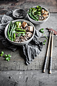 Vegane Suppe mit gebratenem Tofu, Sobanudeln, Pilzen und grünem Gemüse (Asien)