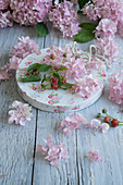 Hydrangea flowers and raspberry sprigs on box lid with vintage pattern