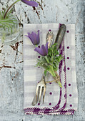 Pasque flower as a napkin decoration on silver cutlery