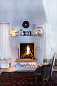 Seating area in front of festively decorated open fireplace in country house