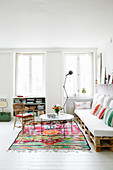Pallet sofa in living room with white floor and brightly coloured accents