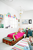 Child's bedroom with interior window decorated in white with brightly coloured accents