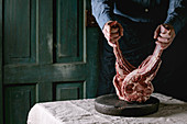 Man s hands holding raw uncooked black angus beef tomahawk steaks on bones on linen table cloth. Rustic style