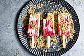 Strawberry rhubarb pie à la mode popsicles have strawberry rhubarb compote layered up with luscious vanilla bean cream and crumbles of pie crust on top
