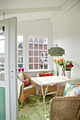 Wicker chairs and flower arrangements in Scandinavian-style conservatory