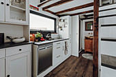 White kitchen counter below mezzanine in tiny house