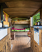 Bunk beds and kitchen in rustic tiny house with wooden floor
