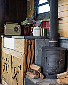 Wood-burning stove next to sink in rustic tiny house
