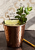 A copper cup with a ginger ale, lime and mint mocktail