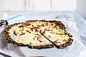 Pizza Bianca with a kale base, herb cream, salmon and mozzarella (keto cuisine)