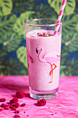 Pink raspberry milkshake in a glass with a flamingo on it