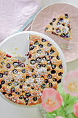 Sunken blueberry cake with icing sugar, sliced