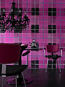 Tulip Table und schwarzer Kristallleuchter vor Wand mit großformatigem pink-schwarzem Karomuster