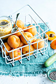 Aprikosendessert mit Chiasamen und frischen Aprikosen in Metallkörbchen