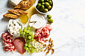 Käse-Schinken-Platte mit Walnüssen, Oliven, Trauben und Brot