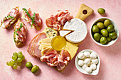 Käse-Schinken-Platte mit Crostini, Oliven und Trauben