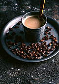 Heisser Kaffee mit Milch und Kaffeebohnen
