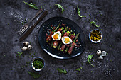 Tasty asparagus with fried quail eggs and herbs placed on bowl