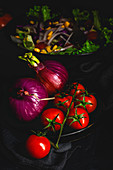 Healthy vegan food with fresh lettuce, cherries tomatoes, red onion and corn on dark background