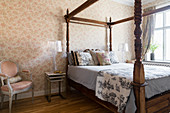Four-poster bed with turned wooden posts in classic bedroom