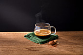 Glass cup of aromatic hot black coffee on green napkin