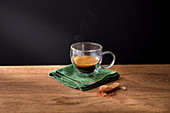 Cup of coffee and cinnamon on wooden table
