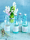 Wasserflaschen mit Namensschildern und Blumenstrauss