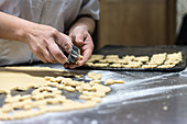 Female chef preparing cookies in kitchen