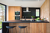 Moderne Küche mit schwarzer Arbeitsplatte und Holzfronten