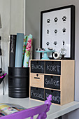 Small chest of drawers with chalkboard fronts and poster of animal tracks
