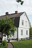 Typical, white, Scandinavian country house with dark roof
