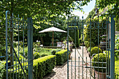 View through garden gate into classic, English-style garden