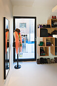 Hallway with shoe rack and mirror next to a glass door