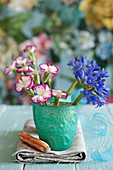 Agapanthus and carnations in turquoise beaker
