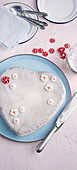 A heart-shaped cake with icing and sugar flowers