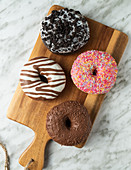Vier Donuts auf Holzbrett