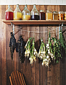 Wooden board with storage jars and herbs and onions hanging underneath