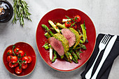 Beef fillet with herb crust on green asparagus