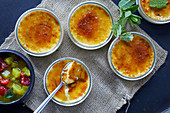 Several creme brulee and fruit compote