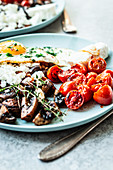 Vegetarian English breakfast with fried egg, mushrooms, tomatoes and feta