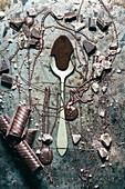 From above top view spoon with chocolate spilled over rustic metal surface background