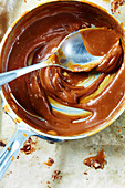 Caramel sauce in a saucepan with a spoon