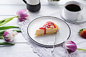 Vegan cheesecake with strawberry sauce and grated rice milk white chocolate