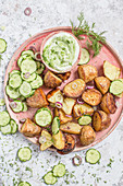 Roasted potato salad with cucumber and dill and yoghurt dressing, served on pink plate