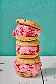Close-up image of three raspberry ice cream sandwiches with chocolate chip cookies